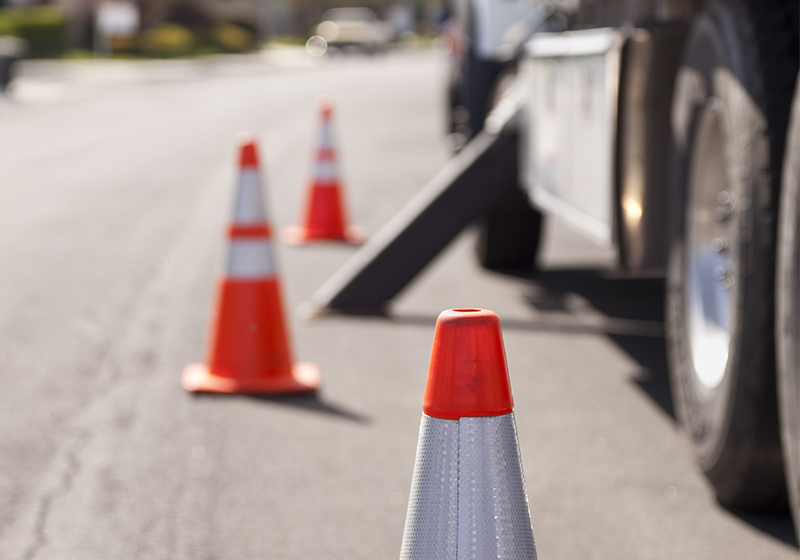 Photo of an Omni Construction vehicle parked on the side of a road with safety cones to alert passing vehicles of an over-sized construction vehicle.